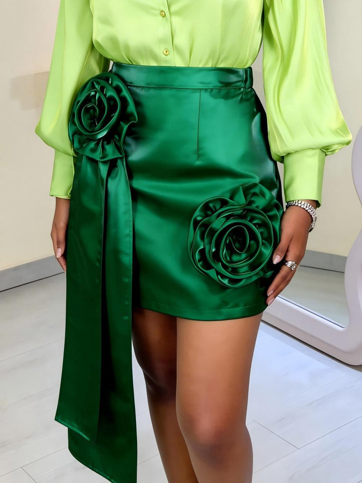 Women’s satin skirt with floral ruffle design and fitted bow detail.