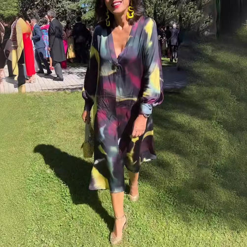 Women's flowing midi dress with abstract print, V-neckline, balloon sleeves, and decorative closure StylebySassy