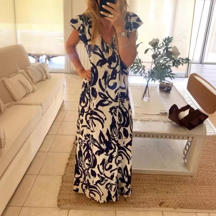 Women's flowing maxi dress with V-neck, flutter sleeves, and side leg slit StylebySassy