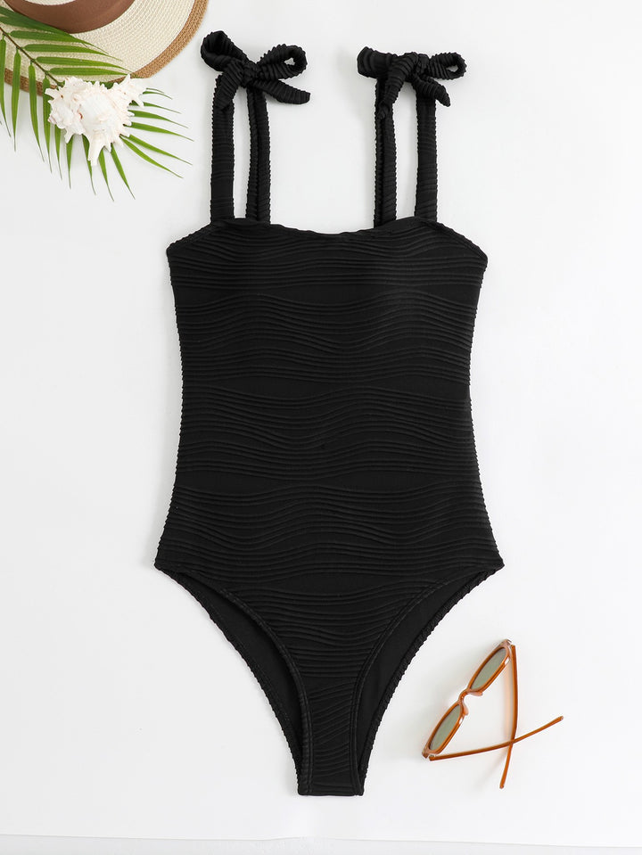 Women's figure-fitting one-piece swimsuit with playful bow details StylebySassy