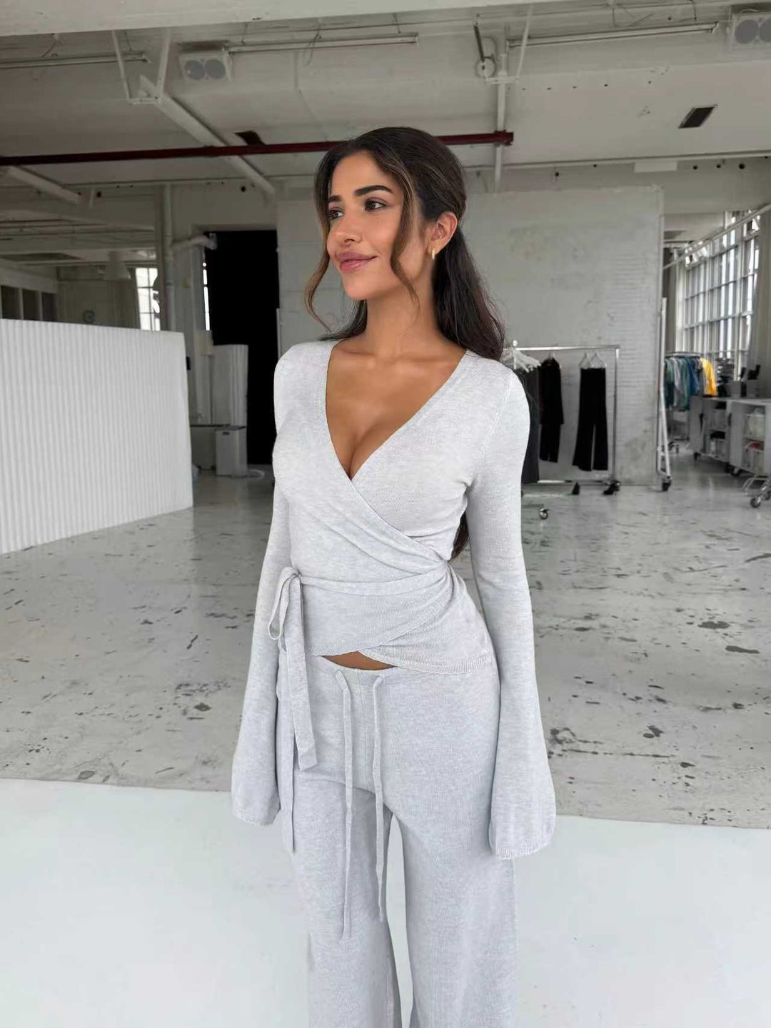 Women's knitted wrap top with tie belt and trumpet sleeves, as well as high-waisted wide-cut knitted pants StylebySassy