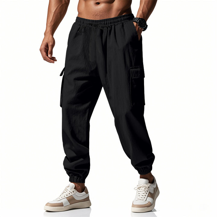 Men's tapered joggers in utilitarian style with elastic waistband, drawstring, and flap pockets StylebySassy