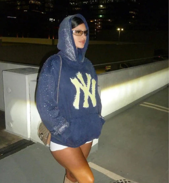 Women's oversized hoodie made of velvet fleece with distinctive logo print, glitter trim, and kangaroo pocket StylebySassy