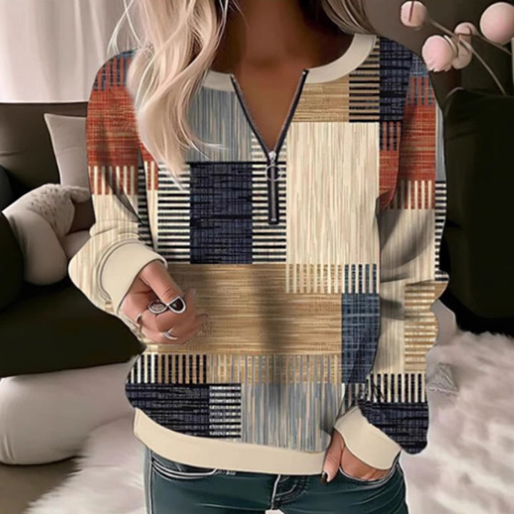 Women's cozy sweater with short zip, graphic patchwork pattern, extended sleeve cuffs, and ribbed hem StylebySassy