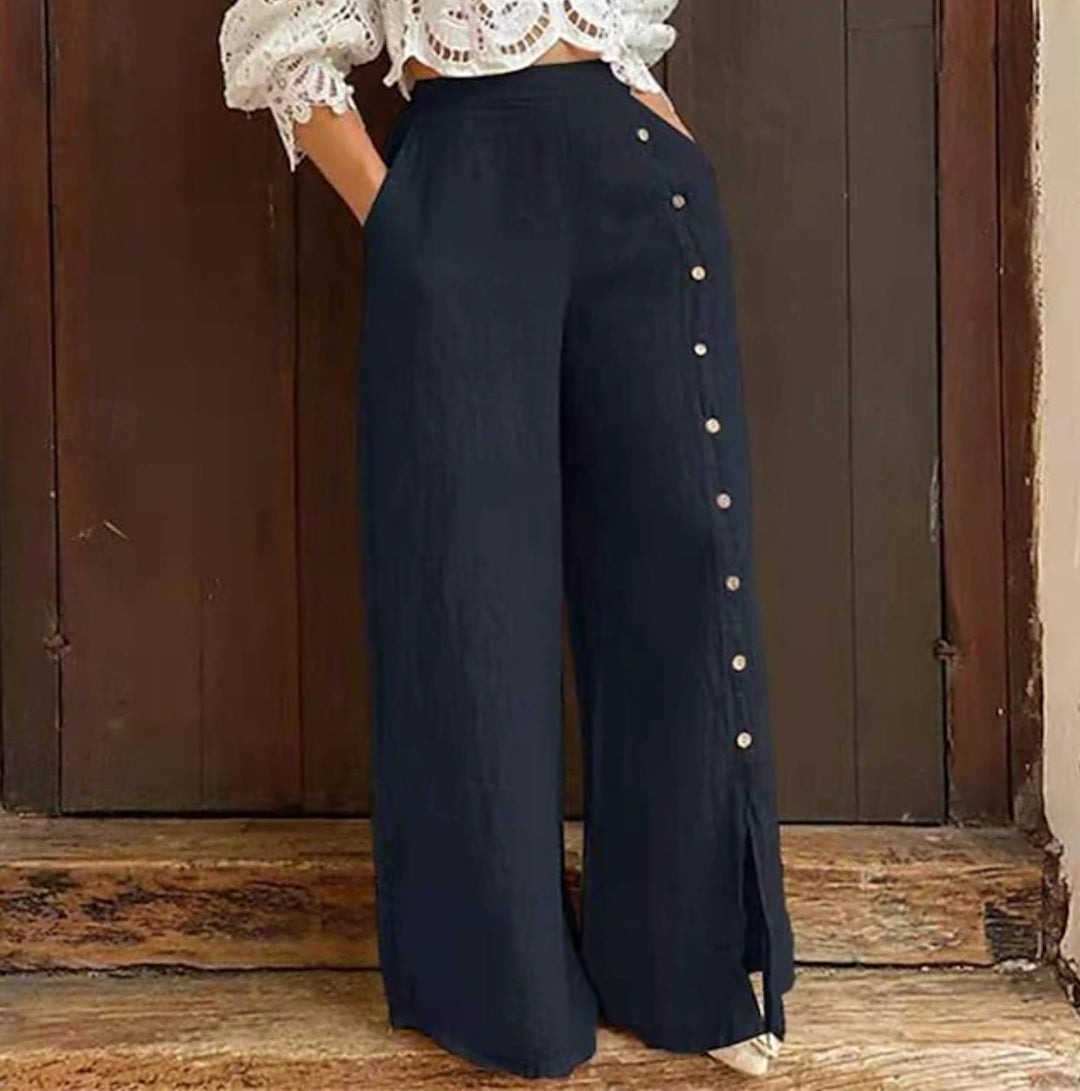 Women's high-waisted linen trousers with a side decorative button placket, side pockets, and wide leg cut StylebySassy
