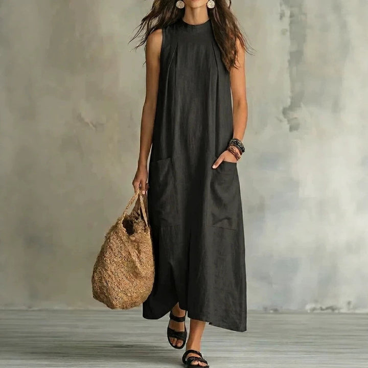 Women’s sleeveless linen maxi dress with standing collar, pleats at the chest, and piled pockets StylebySassy