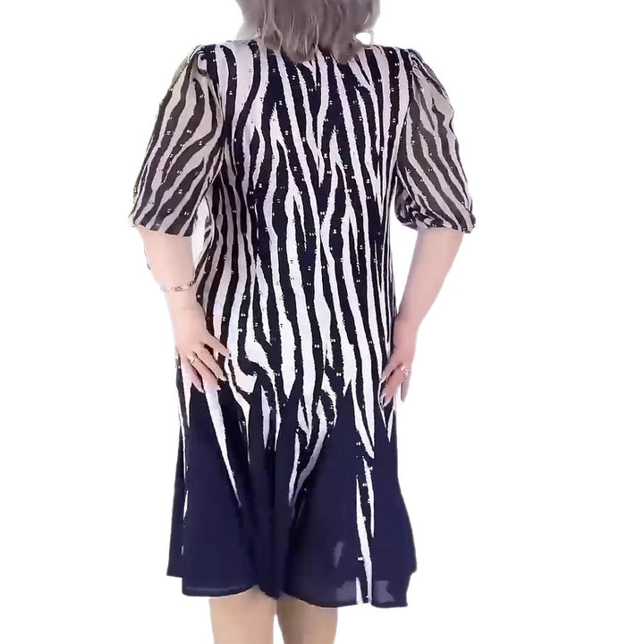 Ladies' fitted midi dress with graphic animal print, transparent puff sleeves and swinging pleated skirt StylebySassy
