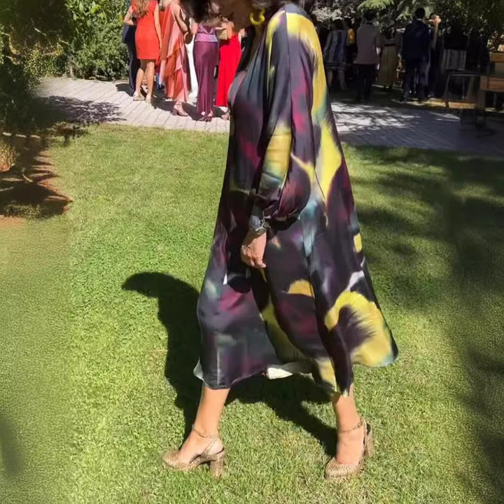 Women's flowing midi dress with abstract print, V-neckline, balloon sleeves, and decorative closure StylebySassy