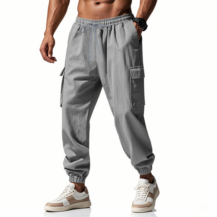 Men's tapered joggers in utilitarian style with elastic waistband, drawstring, and flap pockets StylebySassy
