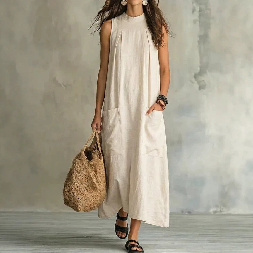 Women’s sleeveless linen maxi dress with standing collar, pleats at the chest, and piled pockets StylebySassy