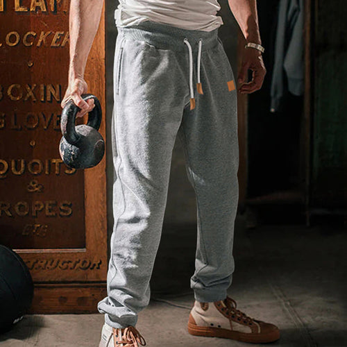 Men's tapered leisure pants made of sweat fabric with elastic waistband, drawstring, and ribbed cuffs StylebySassy