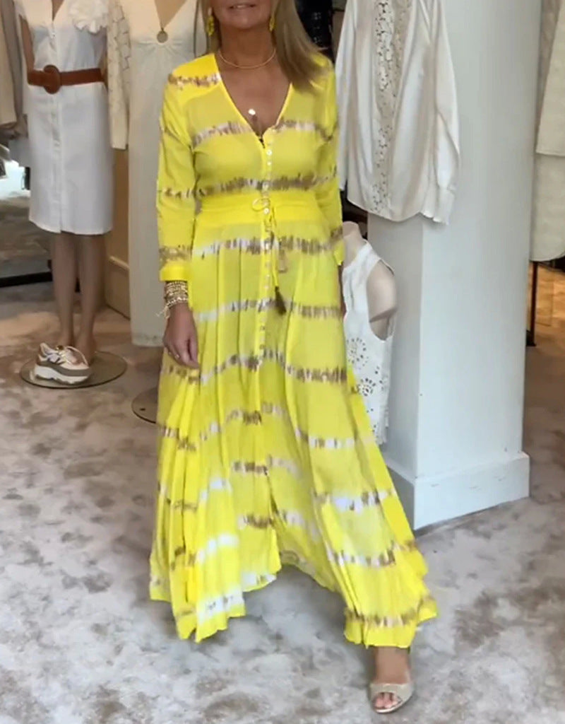 Women's flowing maxi dress with V-neck, full button placket, fitted tassel belt, and pleated skirt StylebySassy