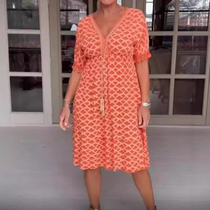 Women's casual midi dress in kaftan style with V-neck, tassel band, gathered empire seam, and fringe sleeves StylebySassy