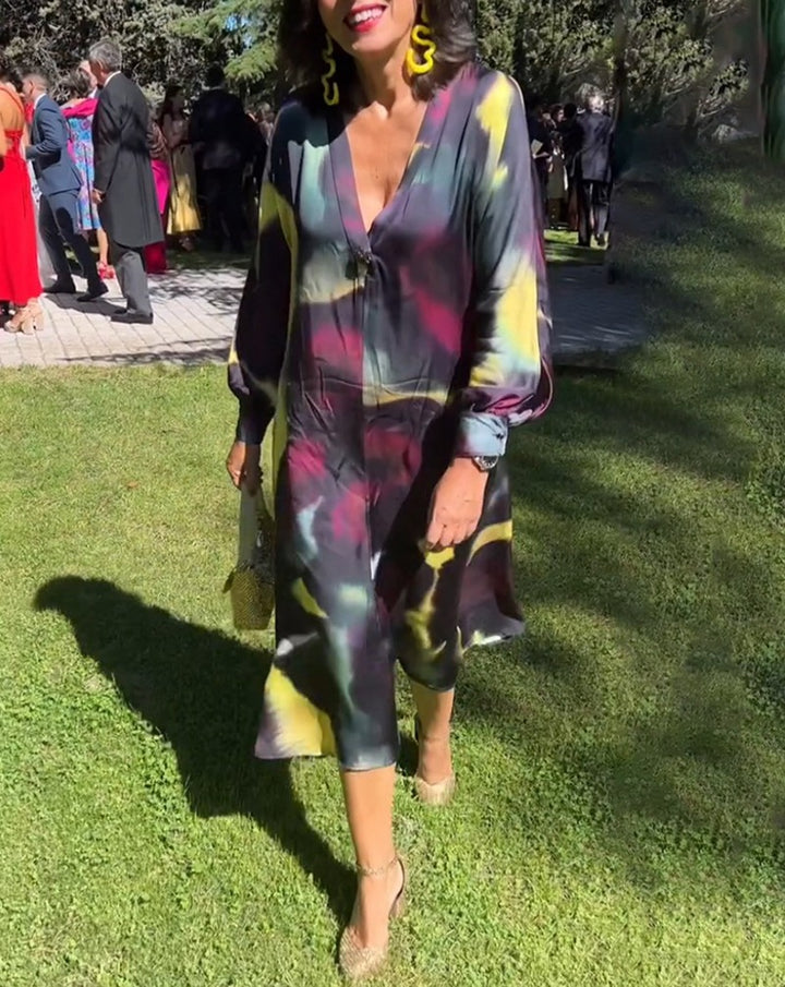 Women's flowing midi dress with abstract print, V-neckline, balloon sleeves, and decorative closure StylebySassy