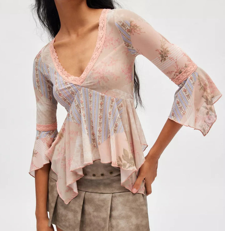Ladies sheer mesh top with V-neck, lace trim, asymmetric ruffle hem, and bell sleeves StylebySassy