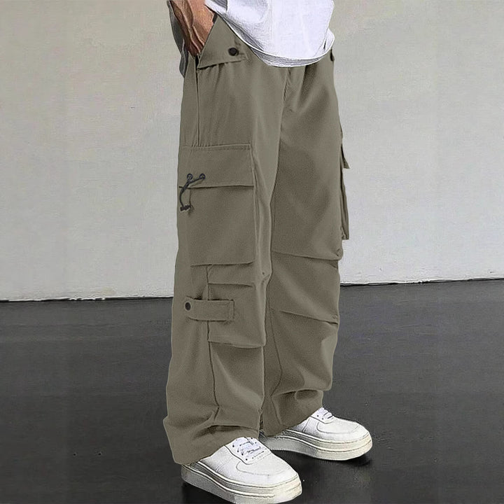 Men's baggy cargo pants with utilitarian flap pockets, drawstring waistband, and reinforced seams StylebySassy