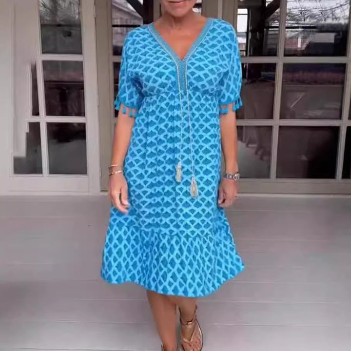 Women's casual midi dress in kaftan style with V-neck, tassel band, gathered empire seam, and fringe sleeves StylebySassy