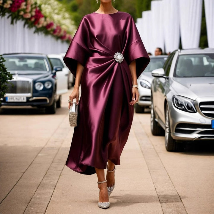 Women's elegant satin kaftan midi dress with kimono sleeves, side draping, and decorative brooch StylebySassy