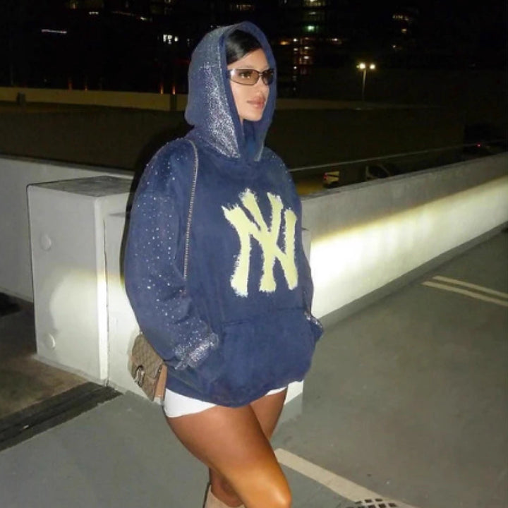Women's oversized hoodie made of velvet fleece with distinctive logo print, glitter trim, and kangaroo pocket StylebySassy