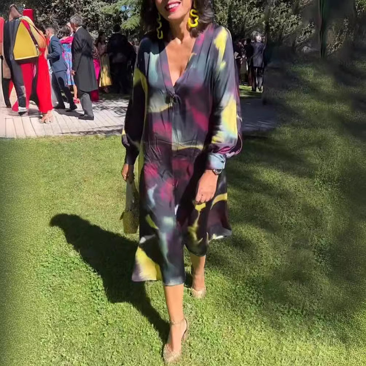 Women's flowing midi dress with abstract print, V-neckline, balloon sleeves, and decorative closure StylebySassy
