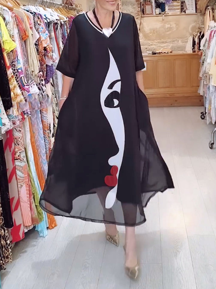 Women's airy chiffon maxi dress with graphic face print, V-neck and side pockets StylebySassy
