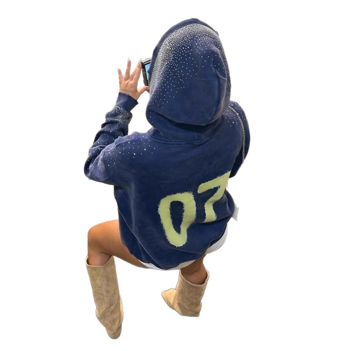 Women's oversized hoodie made of velvet fleece with distinctive logo print, glitter trim, and kangaroo pocket StylebySassy