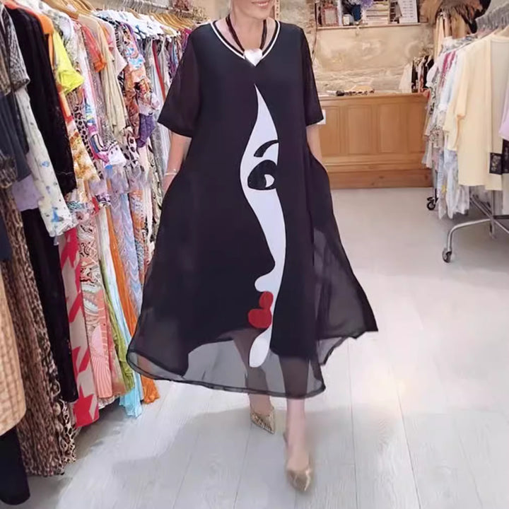 Women's airy chiffon maxi dress with graphic face print, V-neck and side pockets StylebySassy