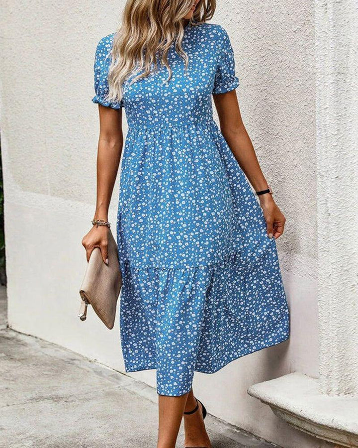 Women's knee-length A-line dress with high round neckline, puff sleeves, gathered empire waist, and tiered hem StylebySassy