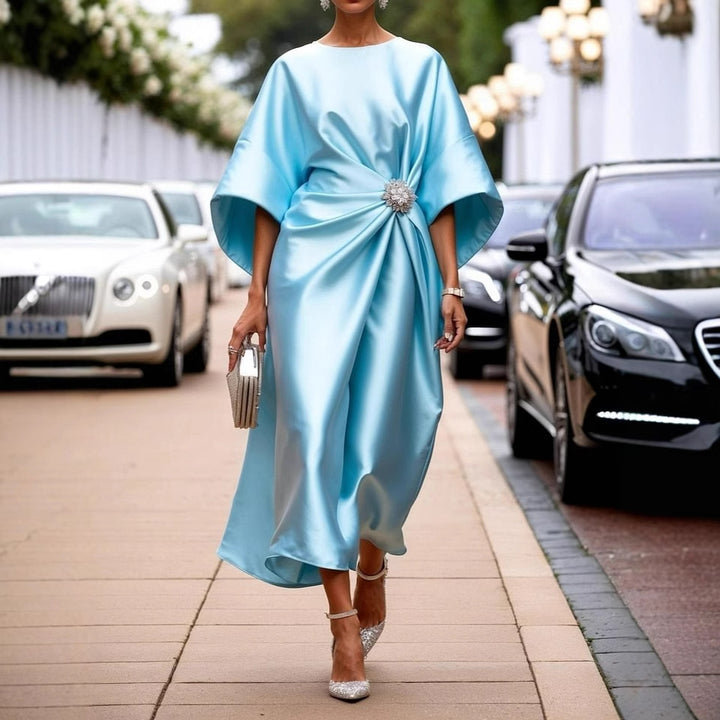 Women's elegant satin kaftan midi dress with kimono sleeves, side draping, and decorative brooch StylebySassy