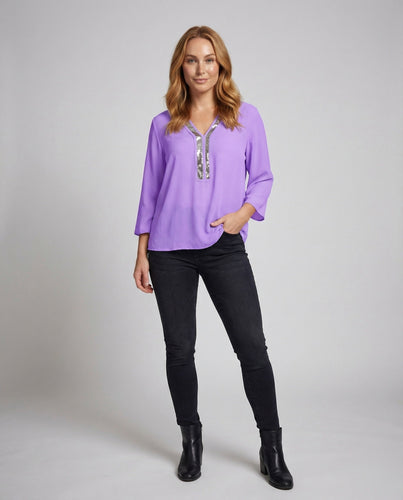 Women's pleated wrap top with tailored waistband and peplum.
